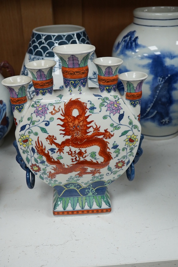 Three blue and white Chinese porcelain vases, a similar jar and cover, plus three stacking jars and covers on stand, a large dragon designed charger on stand and a similar decorated vase, charger 39cm diameter (7). Condi